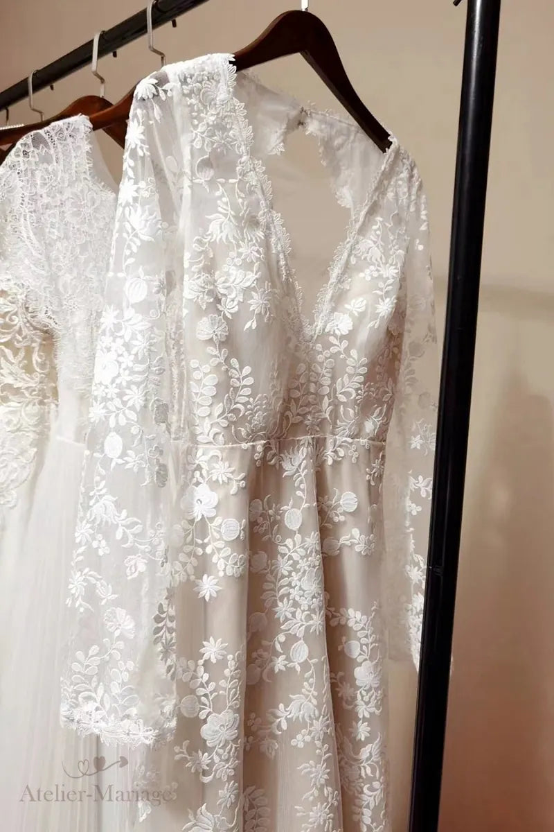 Robe de mariée vintage bohème à manches longues et dos nu suspendue sur un cintre
