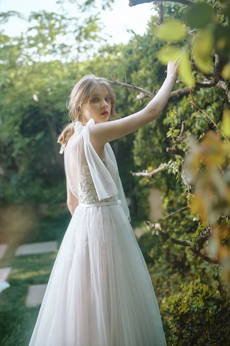 Robe de mariée bohème sur-mesure en dentelle fine et tulle, avec détails floraux 3D, dans un jardin verdoyant