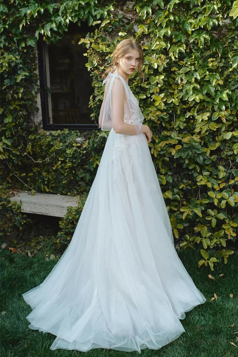Robe de mariée bohème sur-mesure en dentelle fine et tulle, avec dos nu et fleurs 3D, idéale pour un mariage champêtre.