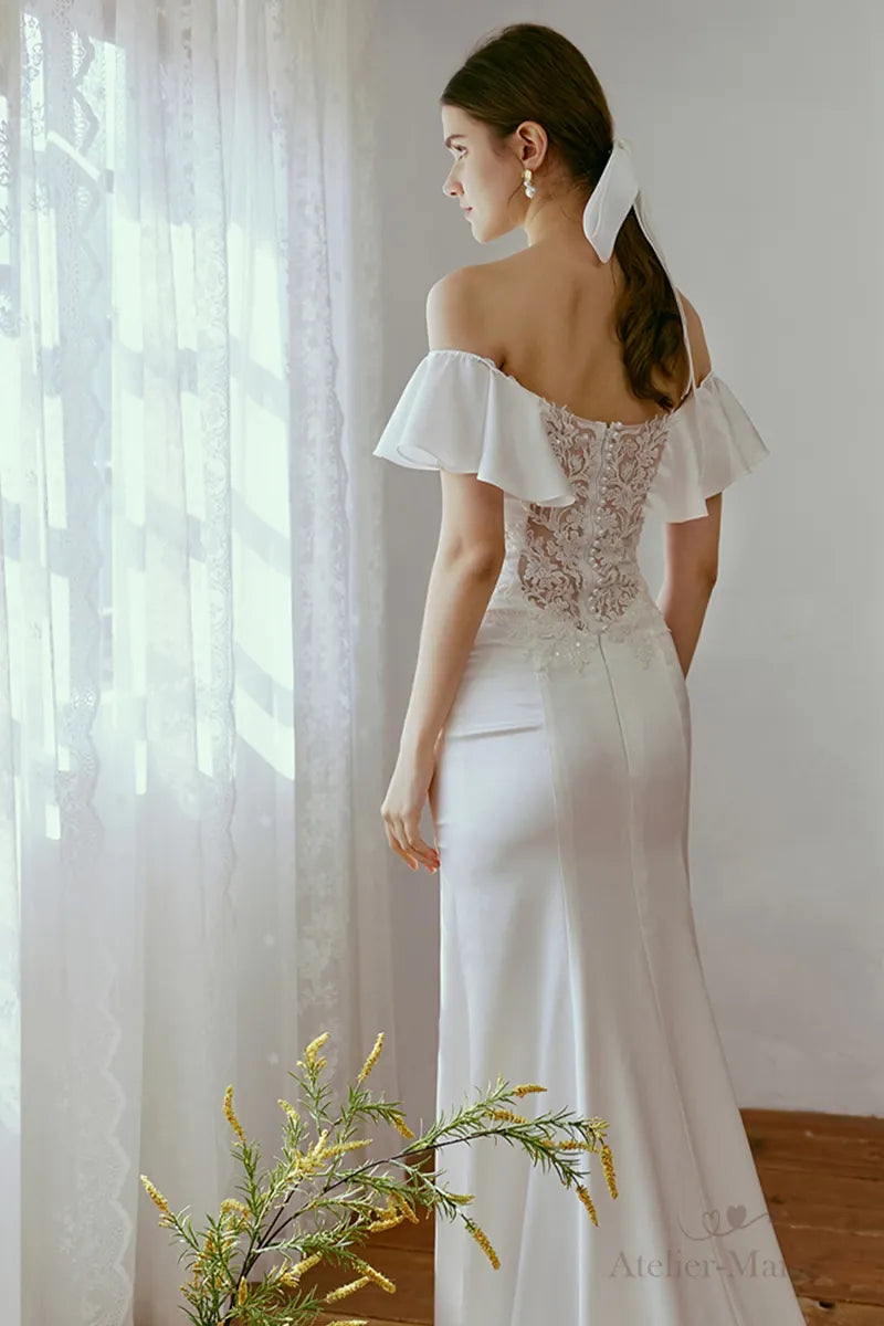 L'éclat du satin fluide blanc sur une robe de mariée col bateau sur-mesure.