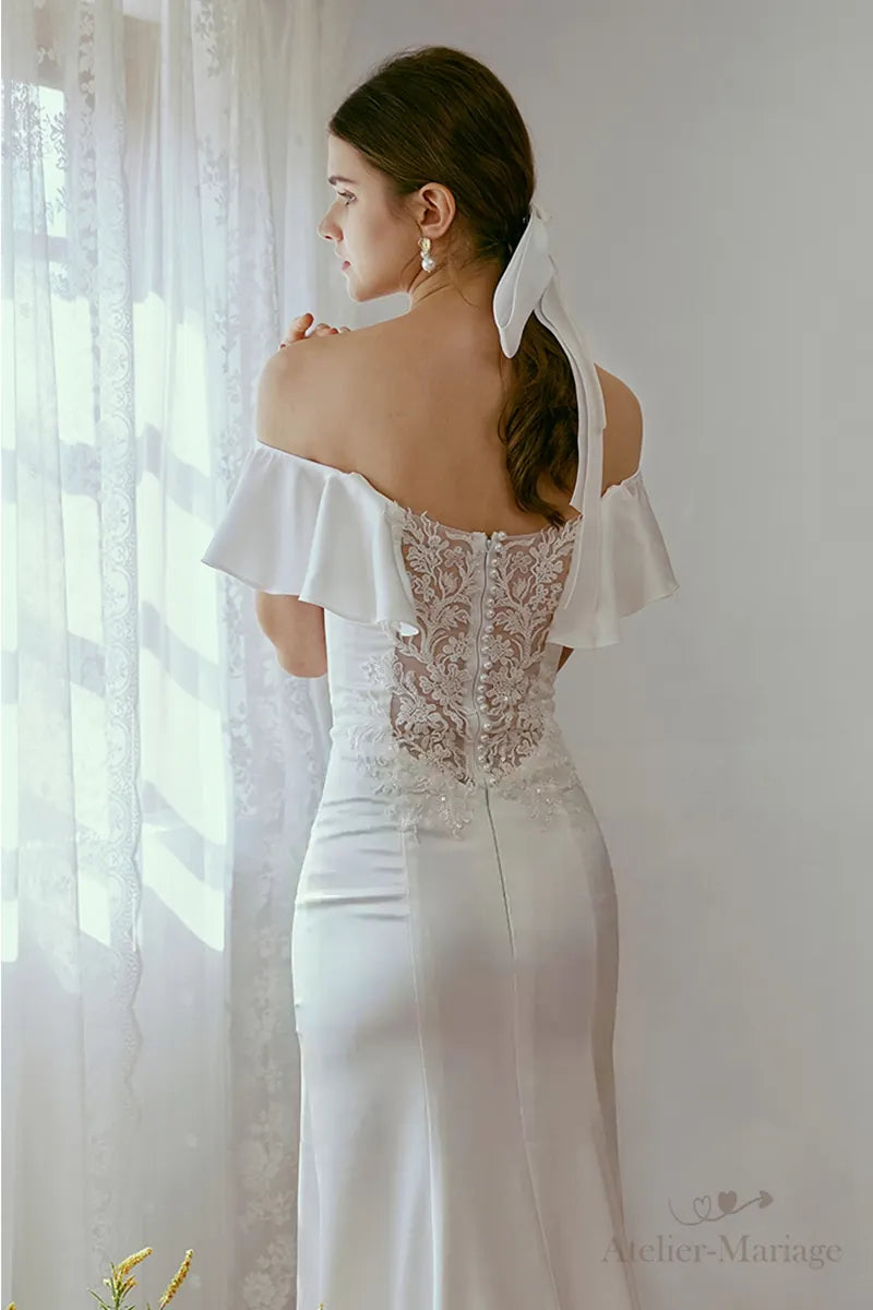 Allure chic et minimaliste d'une robe de mariée sirène à épaules dénudées.