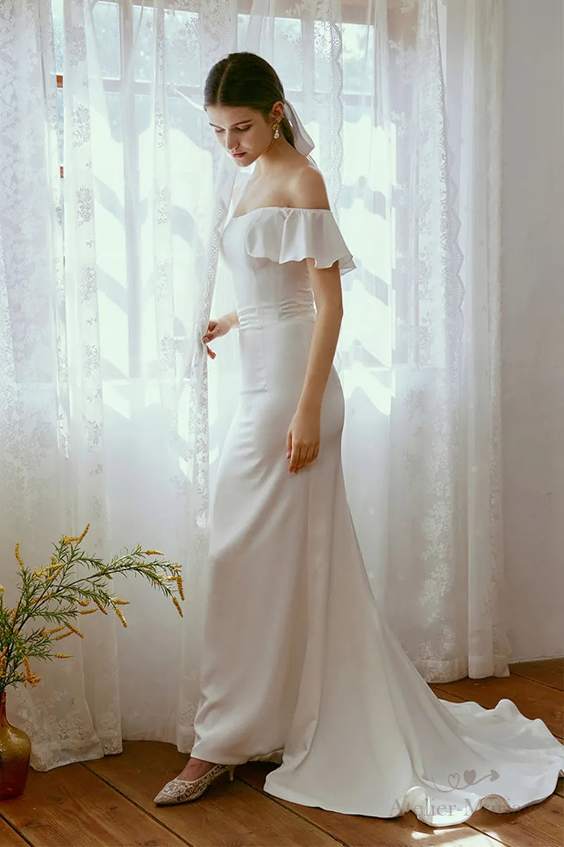 Silhouette romantique d'une mariée portant une robe sirène en satin sur-mesure.