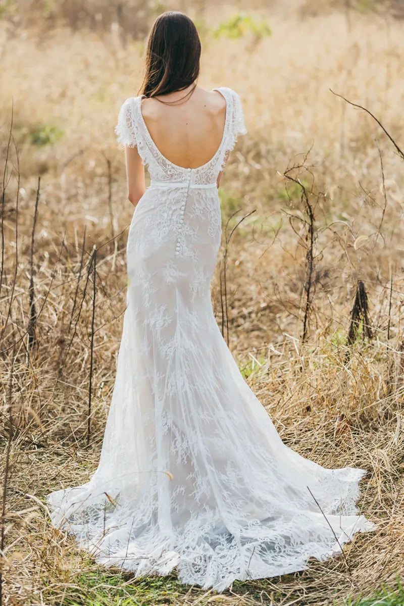 Robe de mariée bohème sur-mesure en dentelle fine avec dos nu et traîne, idéale pour un mariage champêtre