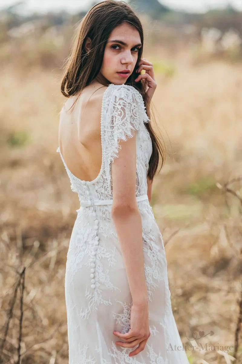 Robe de mariée bohème en dentelle fine avec dos nu et manches courtes, idéale pour un mariage champêtre