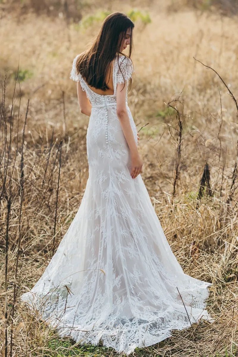Robe de mariée bohème en dentelle fine avec dos nu et traîne, idéale pour un mariage champêtre
