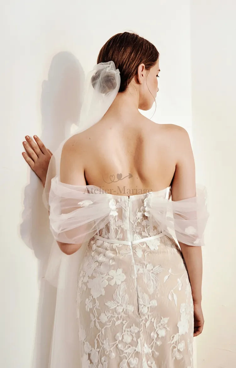 Mariée de dos avec chignon bas sophistiqué à la nuque, robe sirène bohème dentelle manches détachables