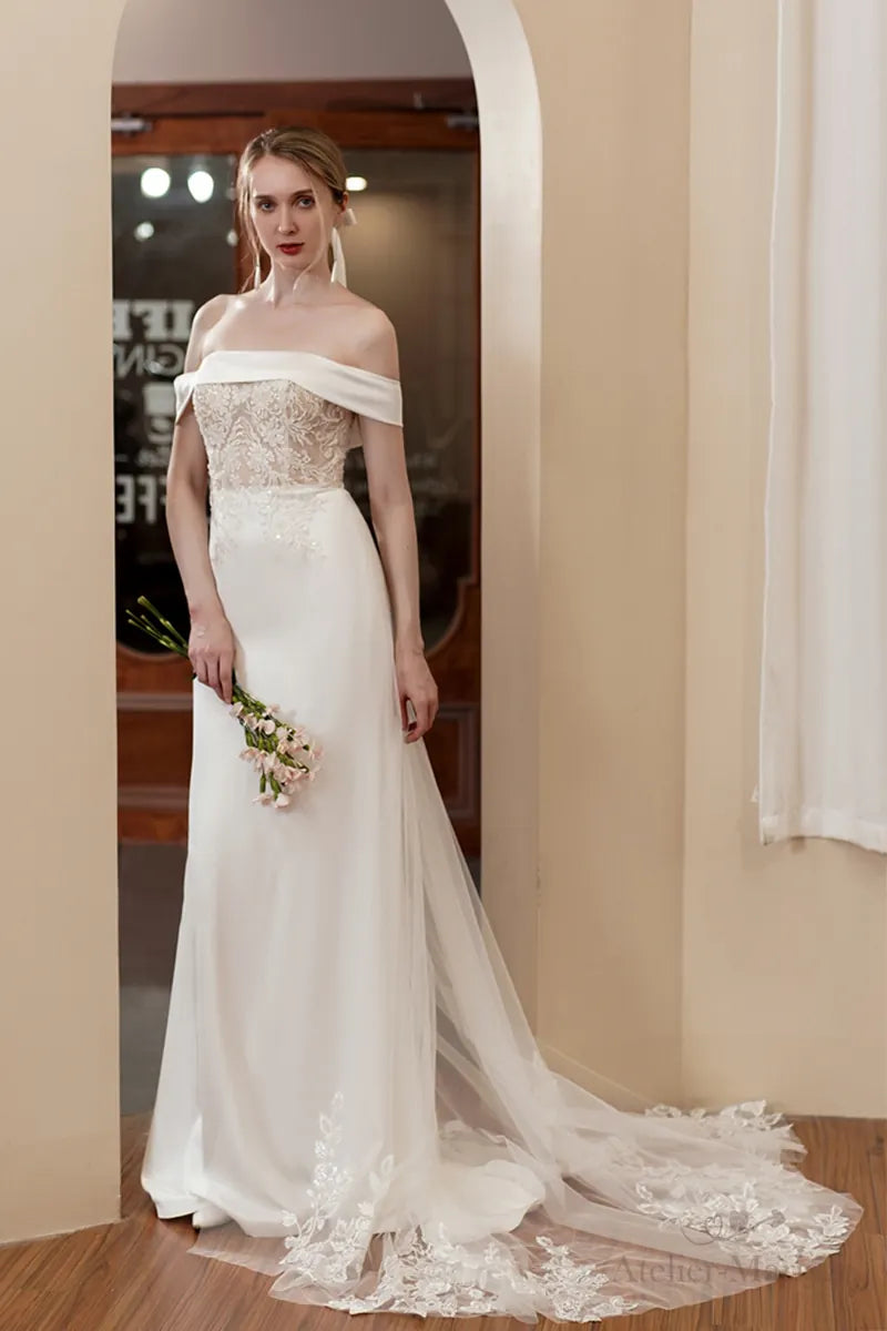 Le tombé impeccable du satin blanc sur une robe de mariée col bateau sur-mesure.