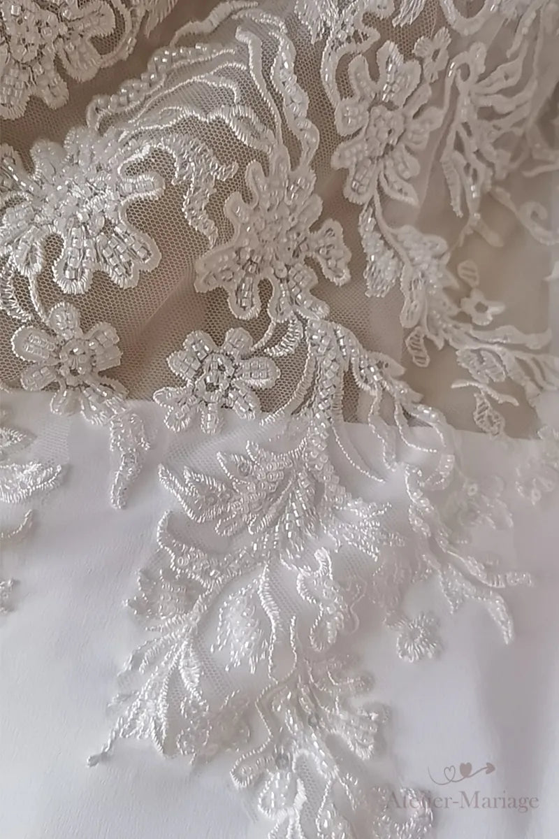 Détail de la texture du satin fluide et des perles brodées sur la dentelle.