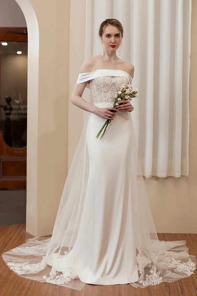 Robe de mariée coupe sirène en satin fluide avec col bateau et dentelle perlée.