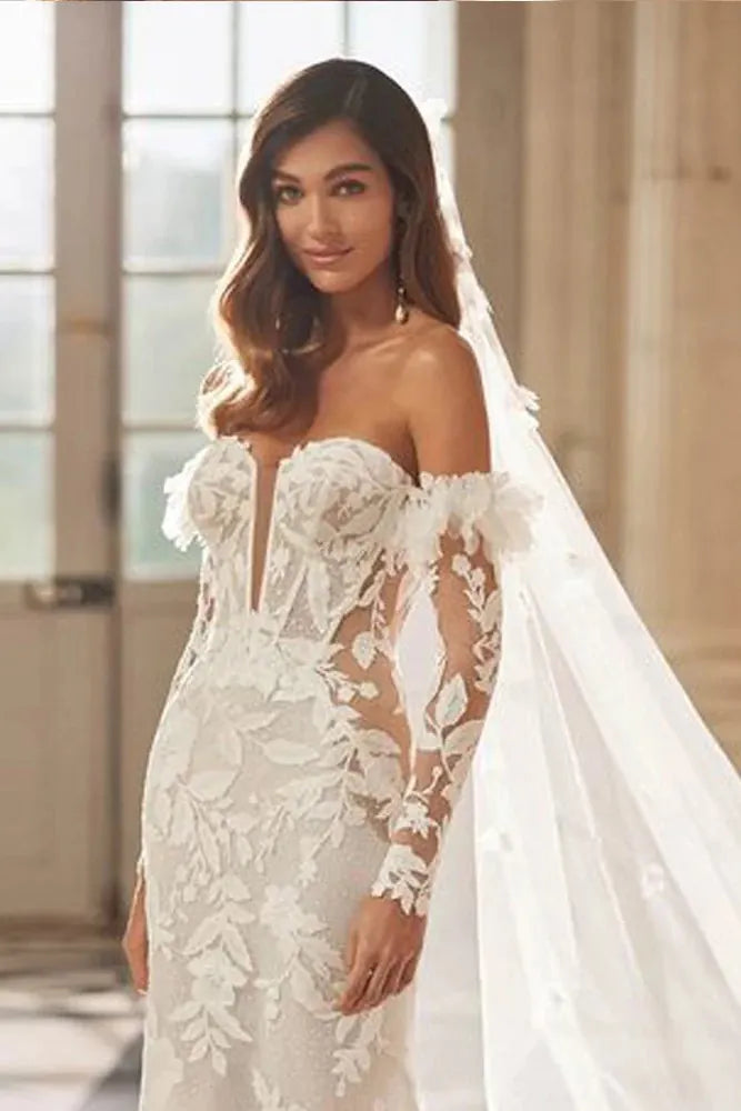 Mariée portant des manches en dentelle transparentes style bohème chic pour couvrir les bras.