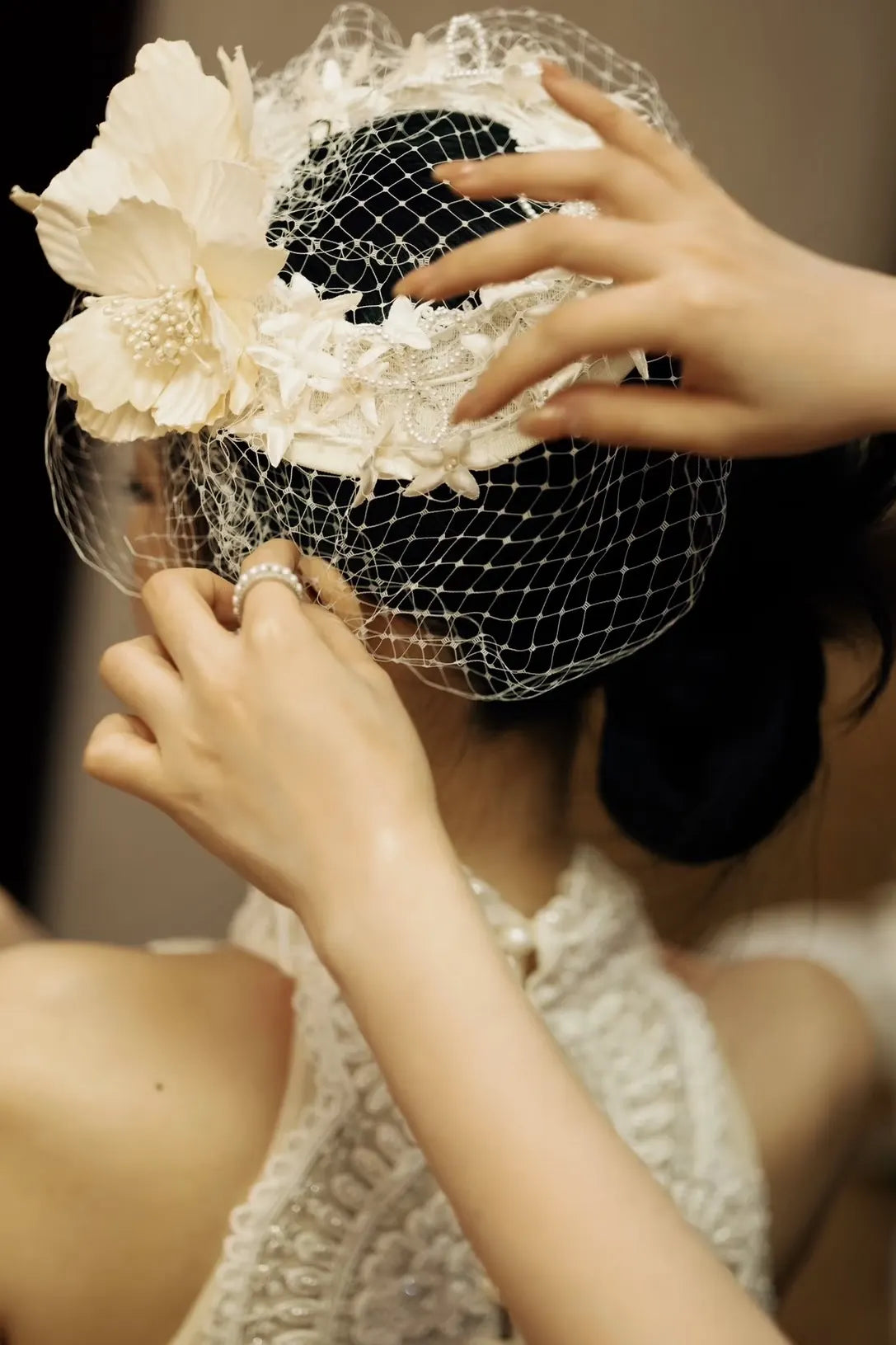 Vue arrière d'une mariée avec un chignon bas, montrant la polyvalence du chapeau Aura ajustable sur n'importe quelle coiffure.