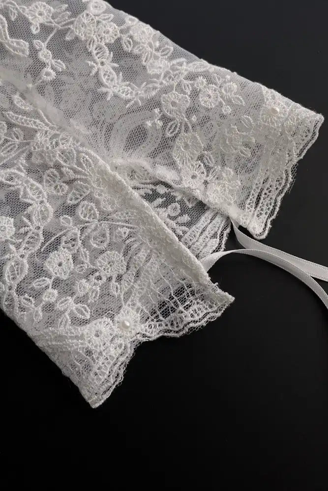 Gros plan sur le ruban d'attache ajustable et confortable des manches amovibles en dentelle.