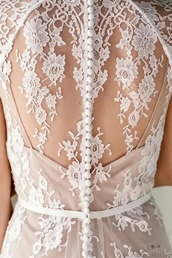 Ligne de boutons décoratifs remontant le dos, un hommage à la haute couture traditionnelle.