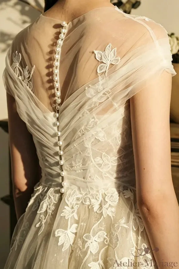 Ligne de boutons perles délicats sur le dos d'une robe de mariée romantique.