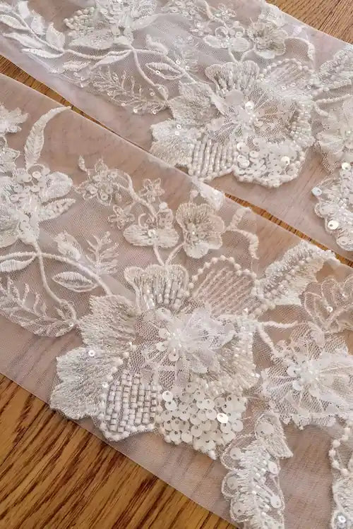 Détails des broderies florales et des paillettes scintillantes sur tulle pour accessoires de mariée bohème chic.