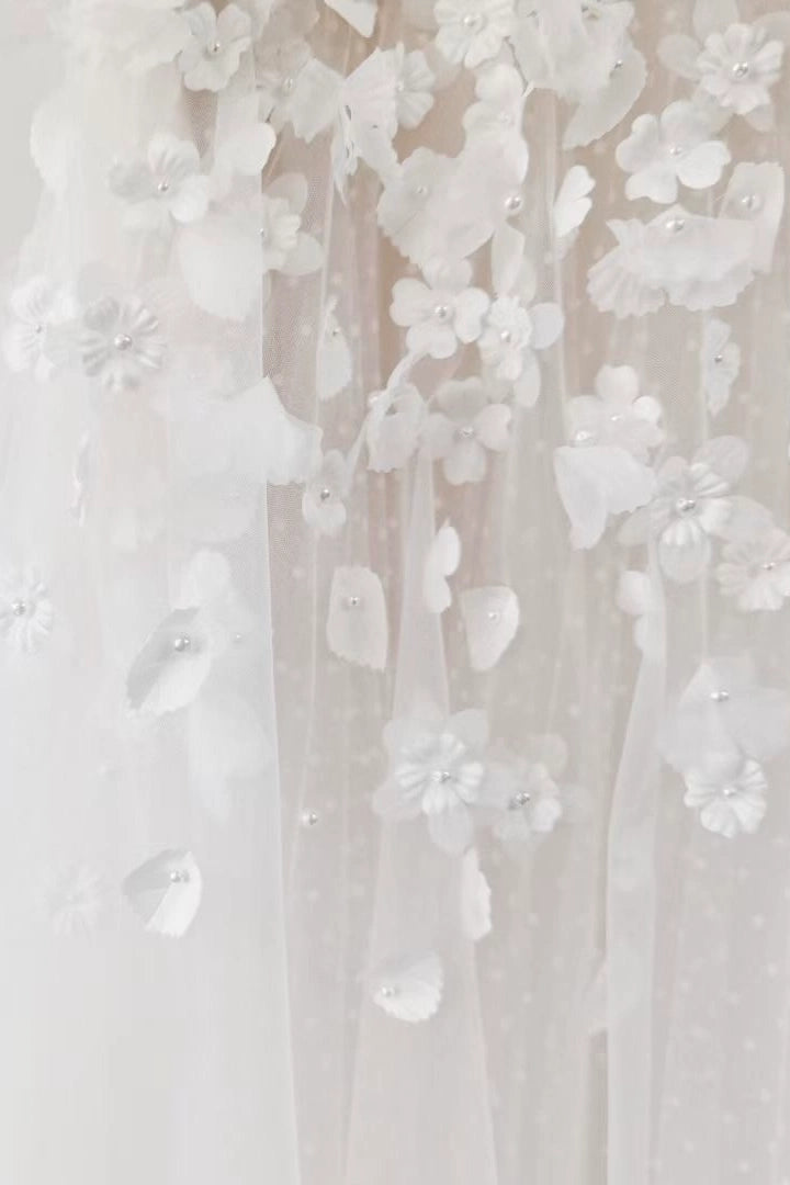 Finitions haute couture des broderies florales sur le bustier de la robe.