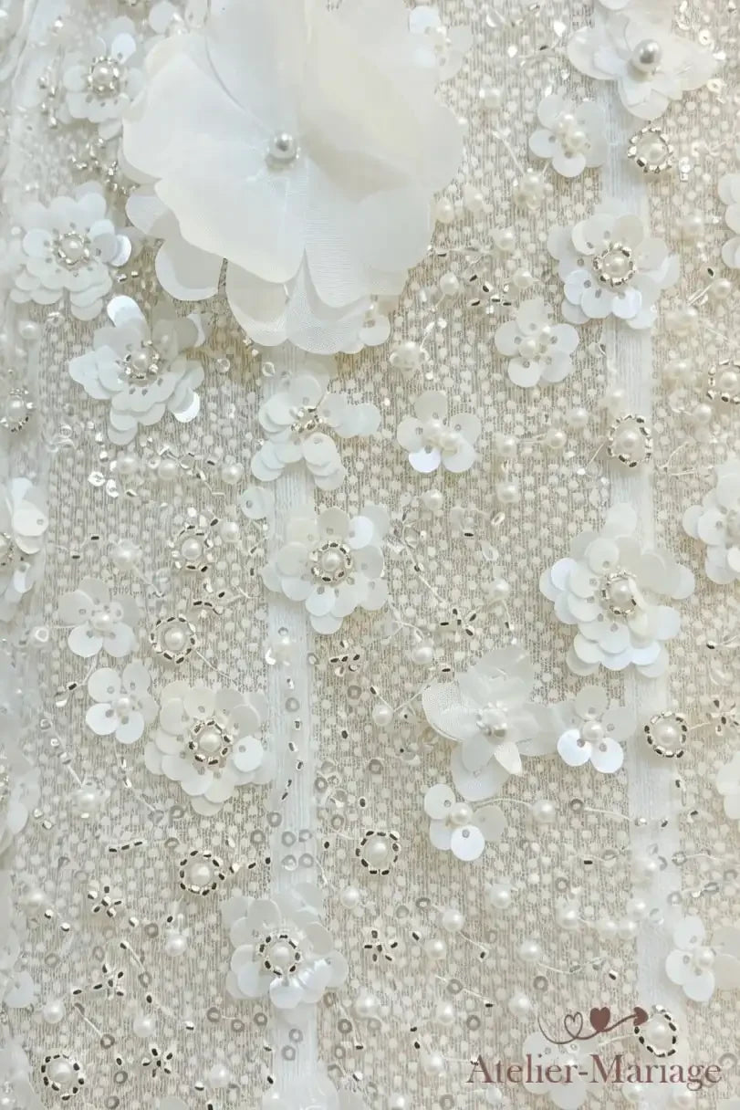 Détail du tissu : petites fleurs en sequins, perles et grande fleur 3D brodées sur tulle
