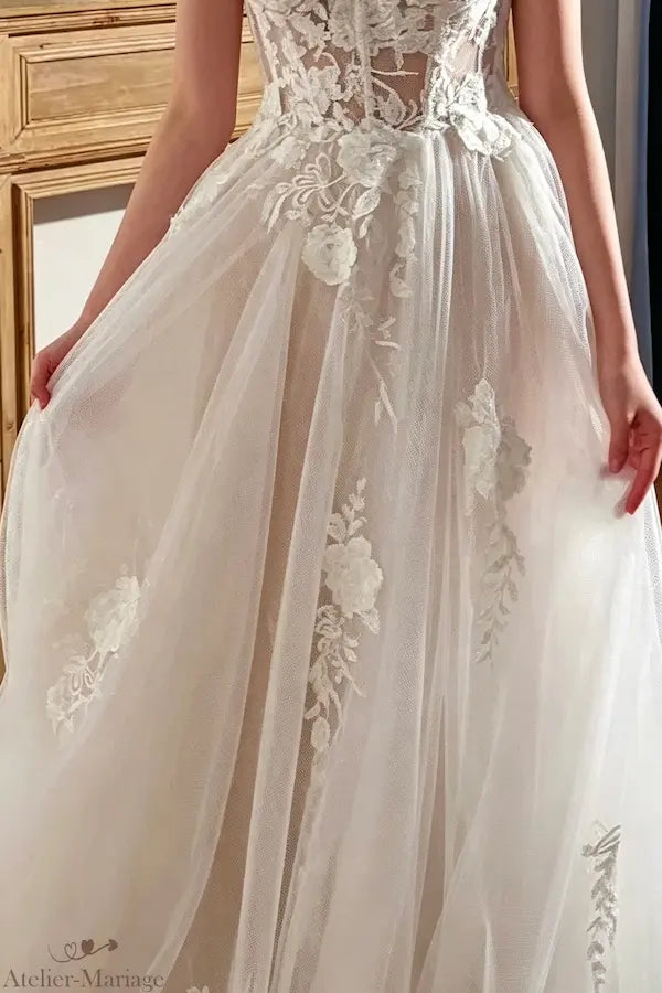 Appliques de dentelle délicates sur une jupe en tulle fluide, Atelier-Mariage.fr.
