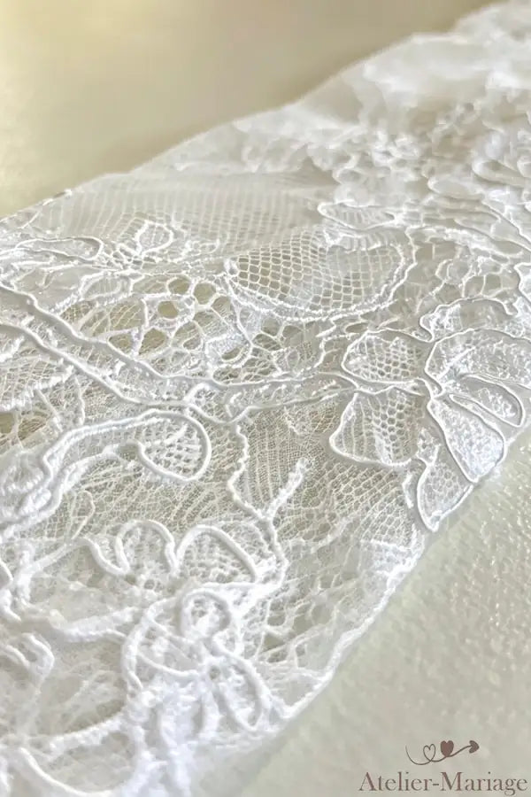 Détails des broderies délicates sur tulle invisible, créant une texture raffinée et haute couture.