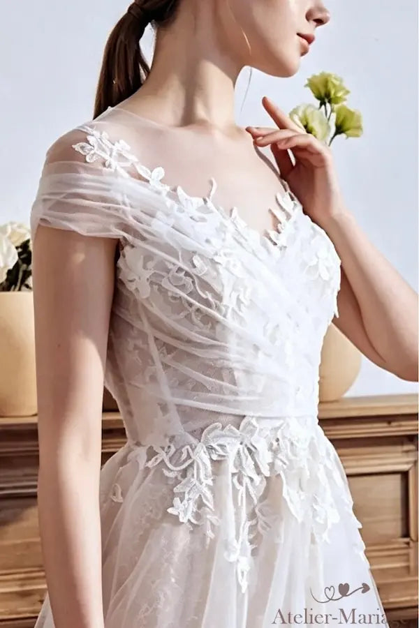 Zoom sur le relief spectaculaire des broderies florales et perles de rosée.