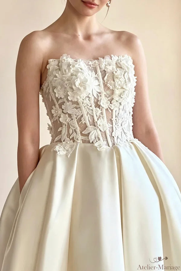 Zoom sur le bustier en cœur orné de fleurs en relief et perles sur satin noble.