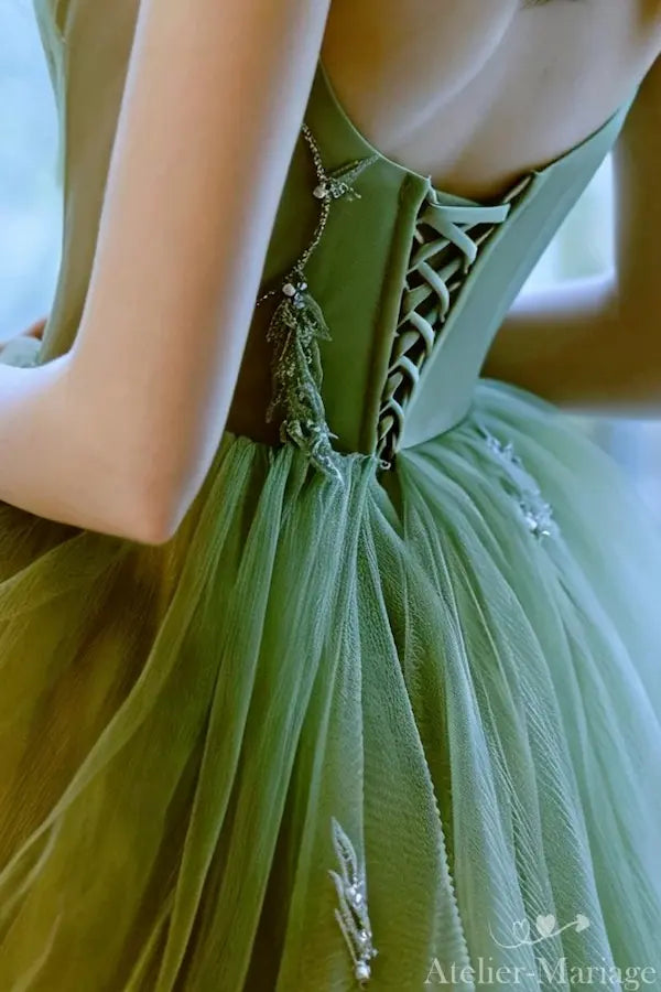 Gros plan sur le laçage corset artisanal et la structure bustier d'une robe de mariée bohème vert sauge.