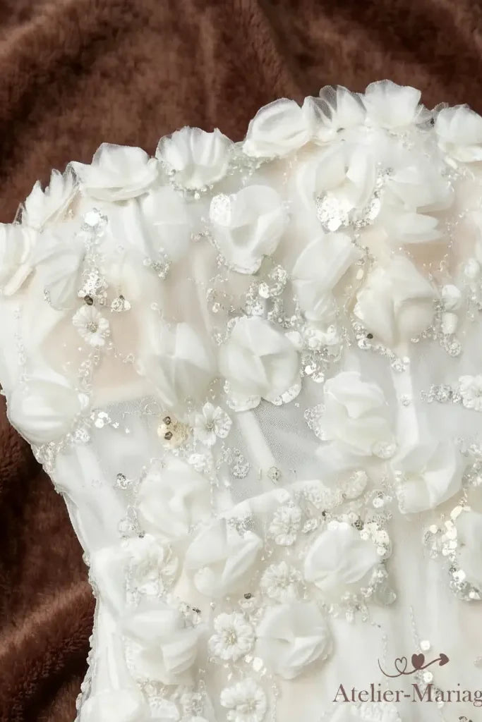 Détail du bord du bustier droit, souligné d'une rangée de fleurs 3D en relief