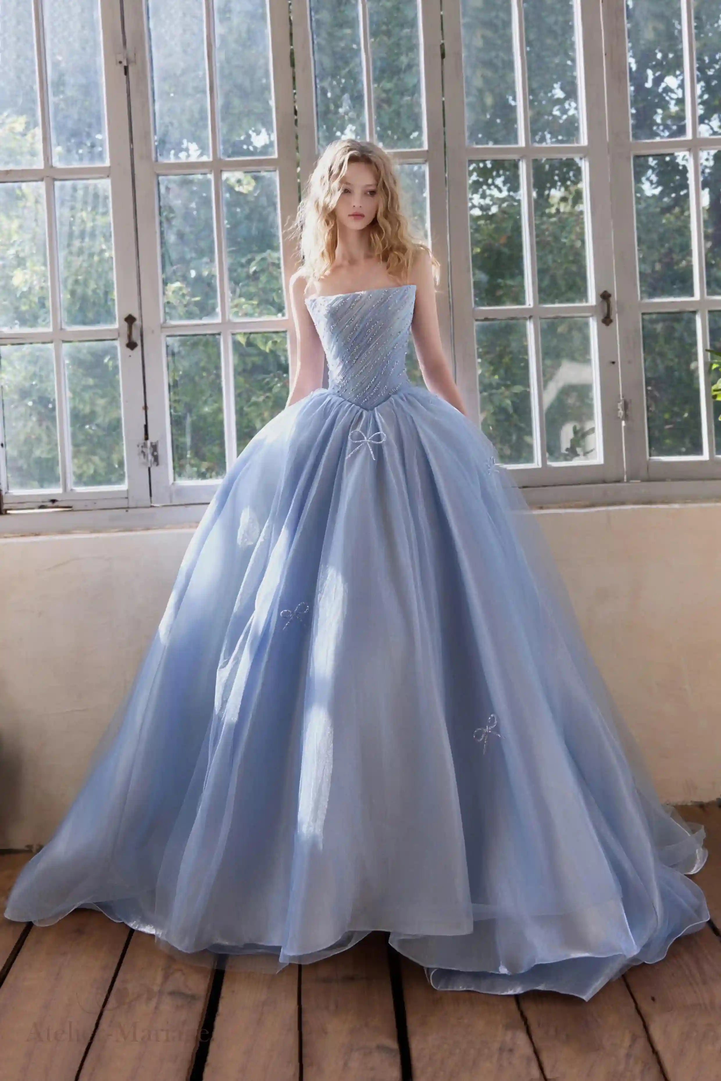 Mariée posant avec élégance dans sa robe princesse bleu étoilé au bustier droit parfaitement ajusté.