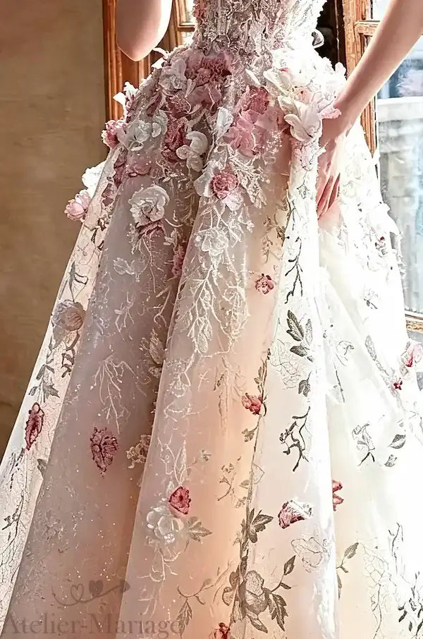 Détail de la répartition des fleurs 3D sur les couches de tulle souple, illustrant la finesse des finitions de l'Atelier.