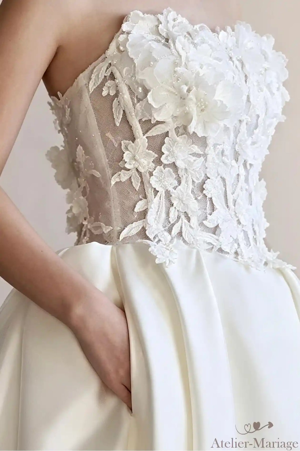 Détails de la taille soulignée par une ceinture en satin et des appliques de fleurs.