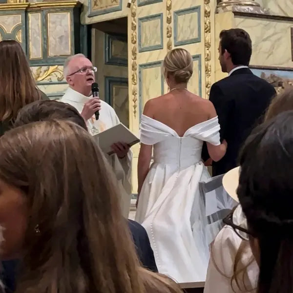 Mariée en robe sur-mesure avec col bardot lors de la cérémonie à l'église