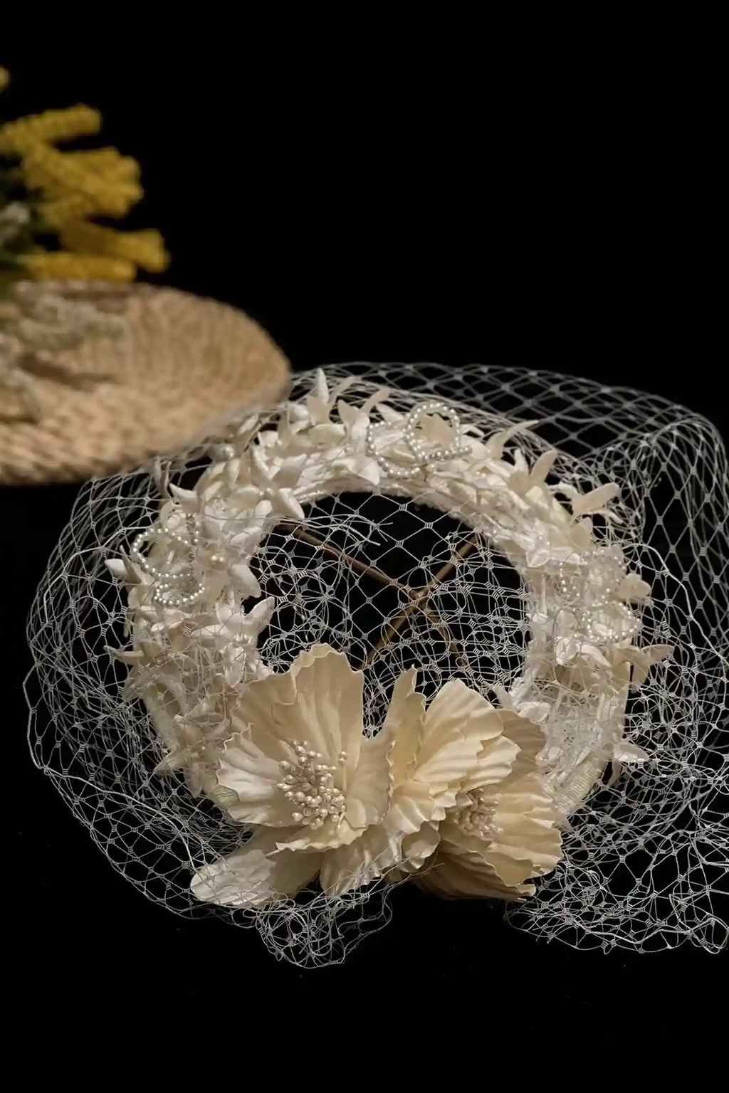 Détail des perles et de la dentelle sur un chapeau de mariée de style vintage.