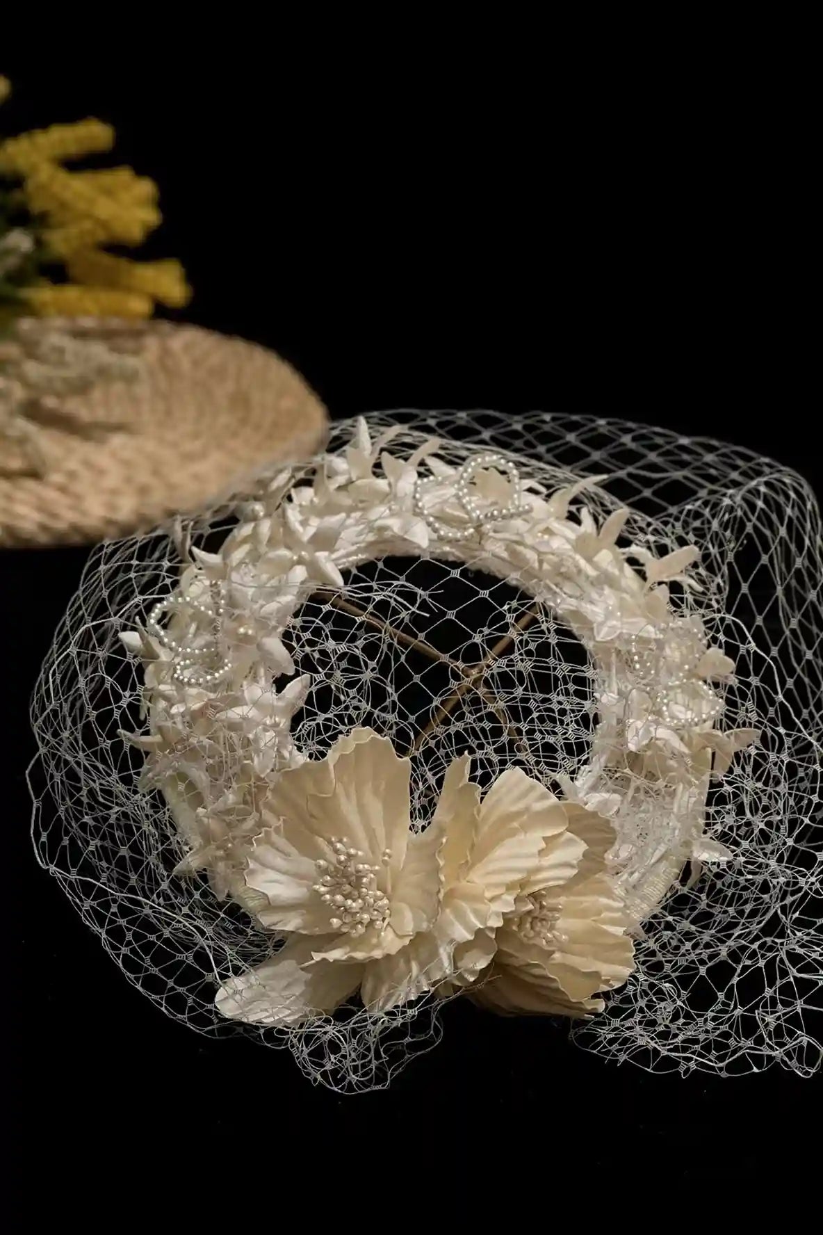 Détail des perles et de la dentelle sur un chapeau de mariée de style vintage.