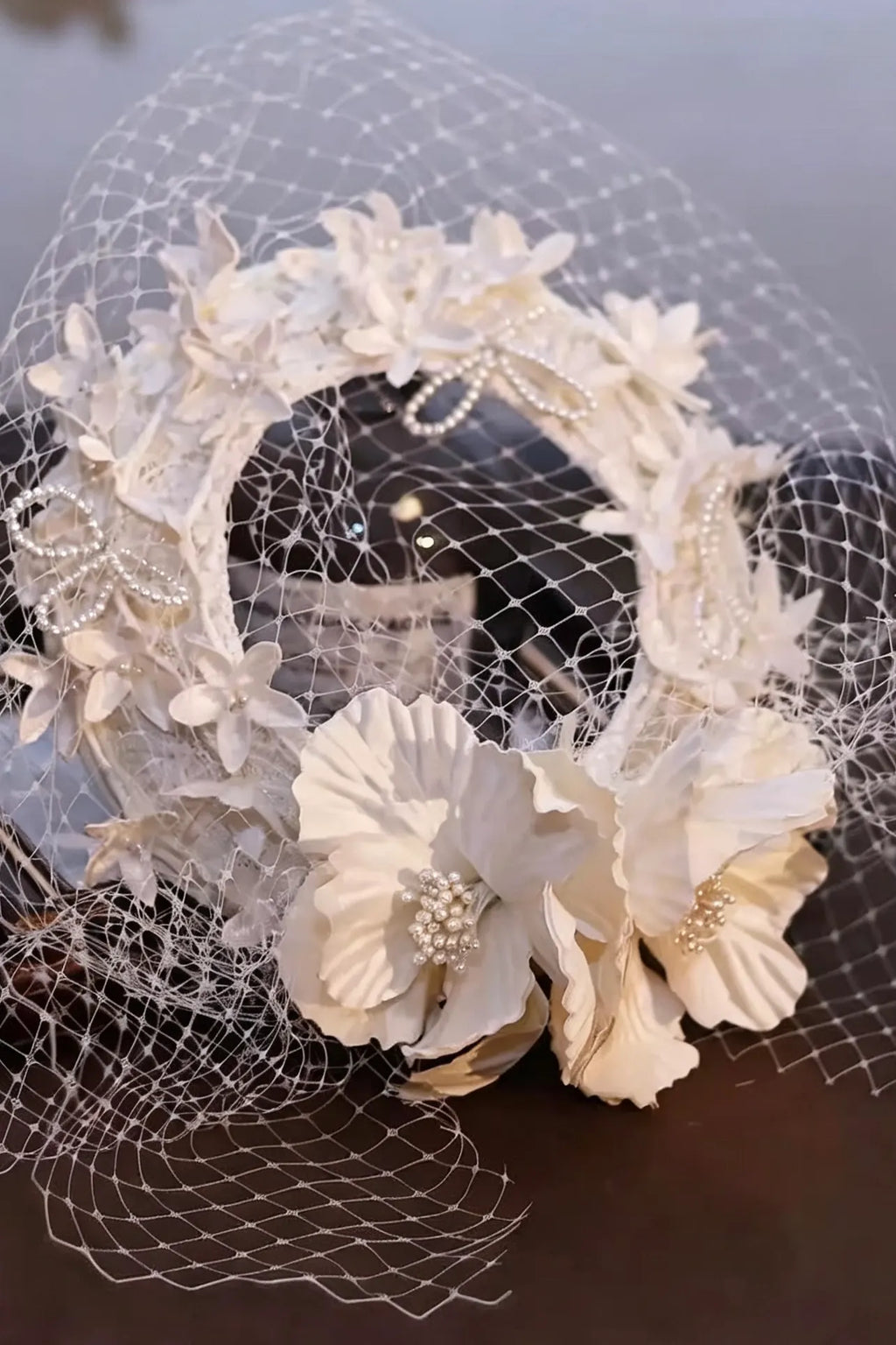 Chapeau de mariée ivoire avec voilette résille et fleurs de satin artisanales.