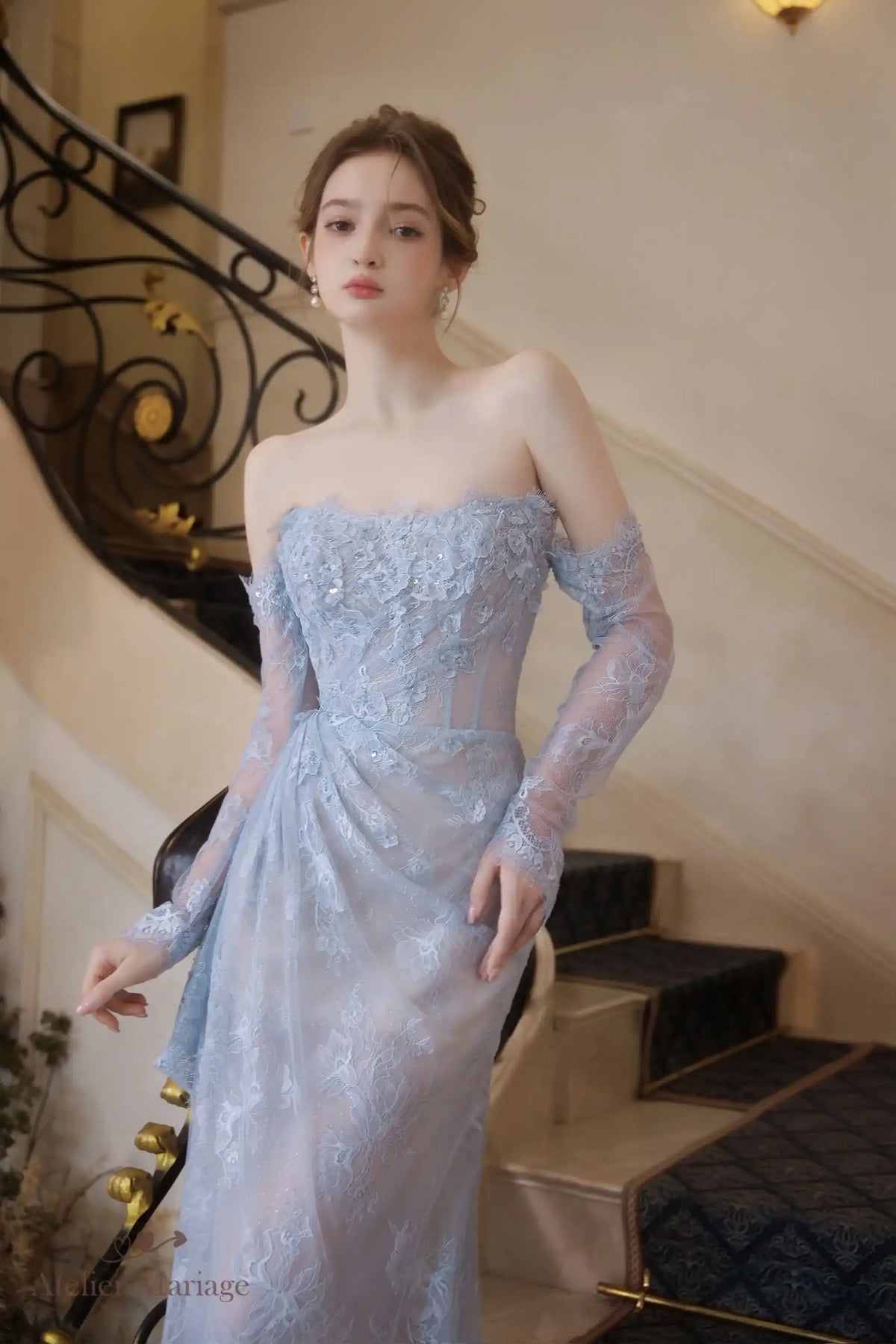 Gros plan sur le corsage en dentelle et les manches longues amovibles de la robe de mariée bleue.