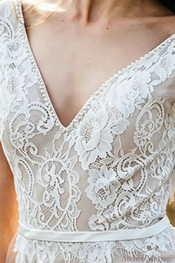 Zoom sur le corsage structuré en dentelle avec jeux de transparence subtils.