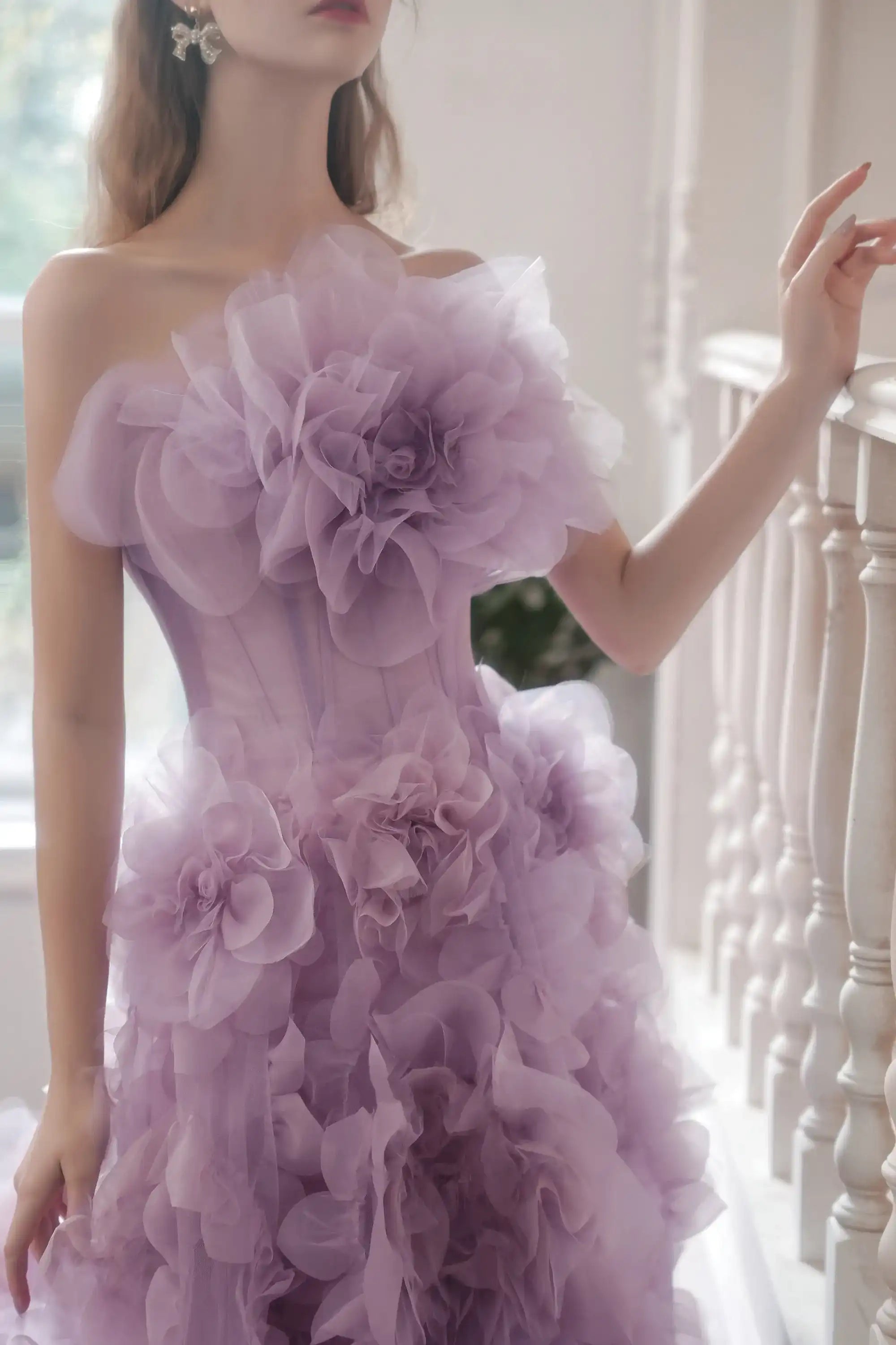 Profil de la mariée mettant en valeur le corsage sculpté et les fleurs XXL en tulle lilas.