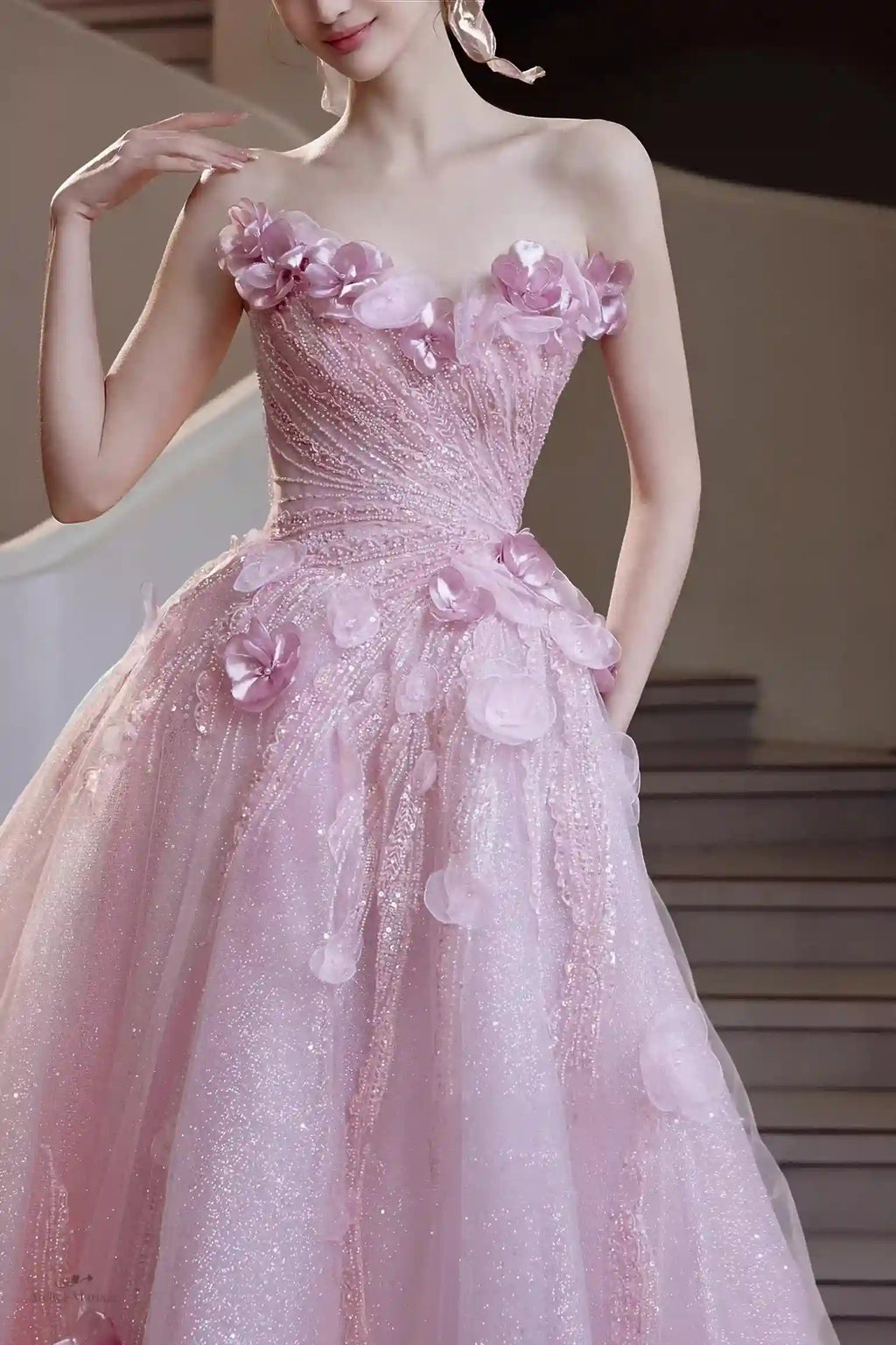 Gros plan sur le corsage de la robe de mariée orné de fleurs 3D et de perles scintillantes.