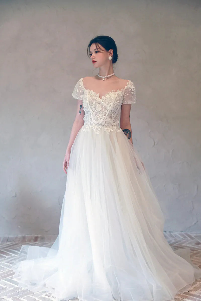 Corsage effet seconde peau en tulle nude transparent avec broderies florales.