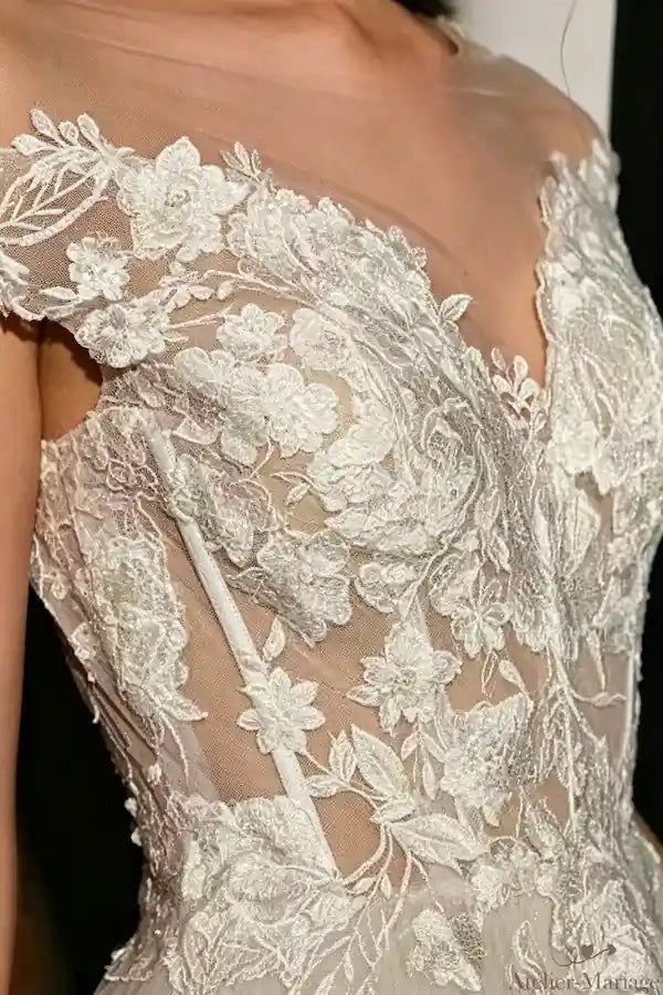 Détail de la dentelle perlée et transparence sur le bustier corset, look mariage champêtre chic.