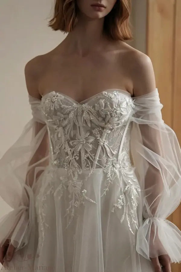 Travail de perlage manuel sur le corset transparent d'une robe de mariée de luxe.