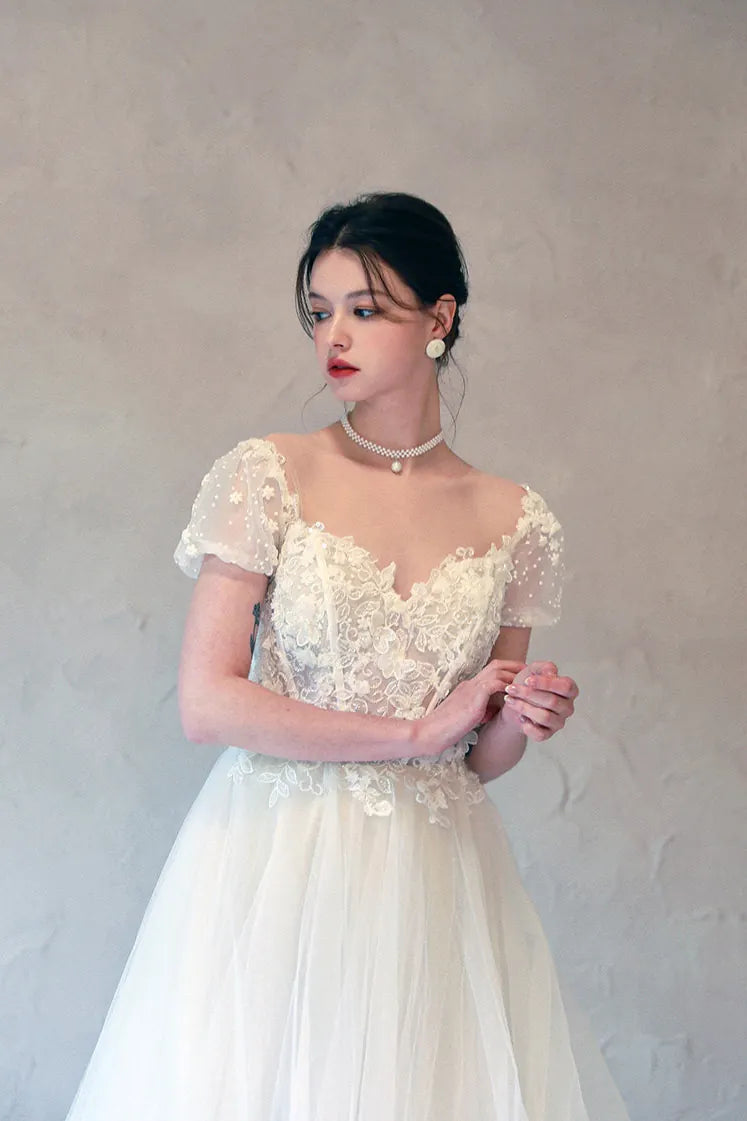 Décolleté plongeant en V profond encadré de fleurs 3D délicates.