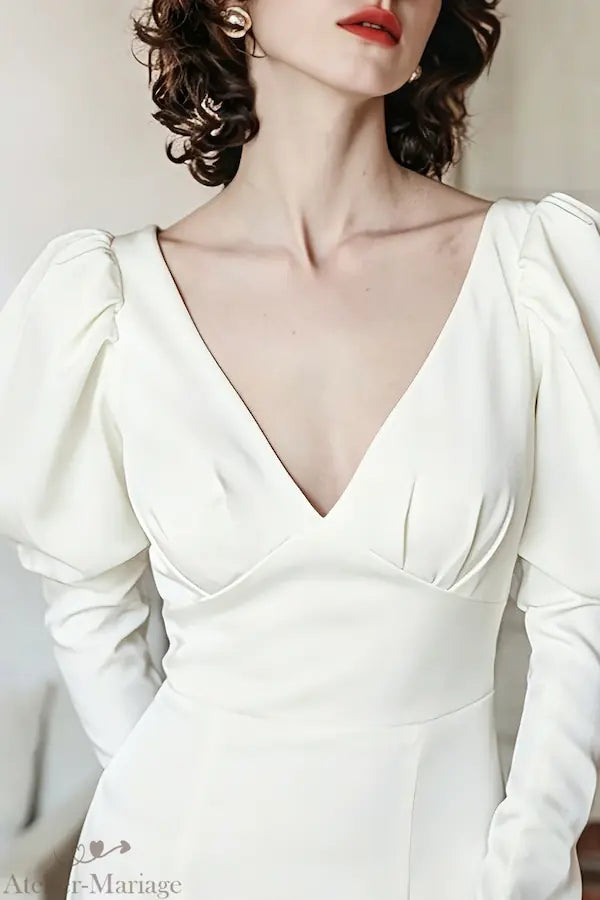 Focus sur le décolleté en V plongeant et le travail de drapé sur le bustier en satin de haute qualité.
