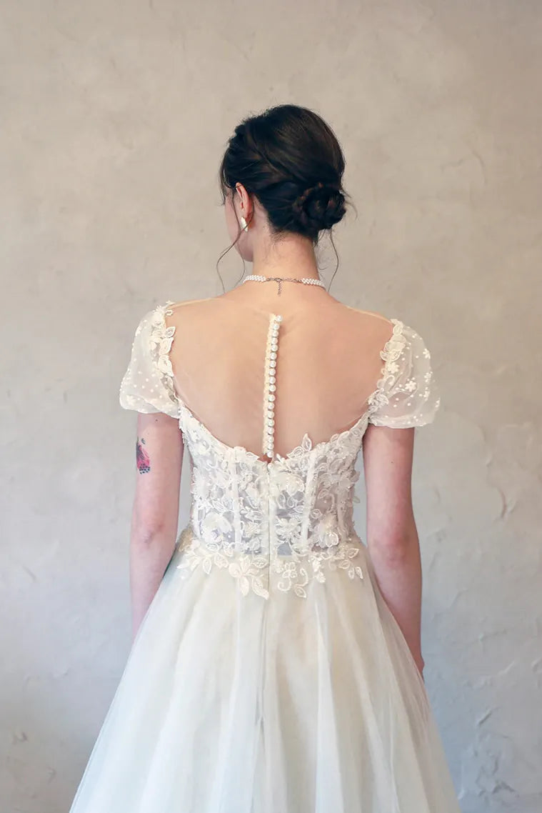 Gros plan sur le nœud satiné élégant au bas du dos et la fermeture invisible.