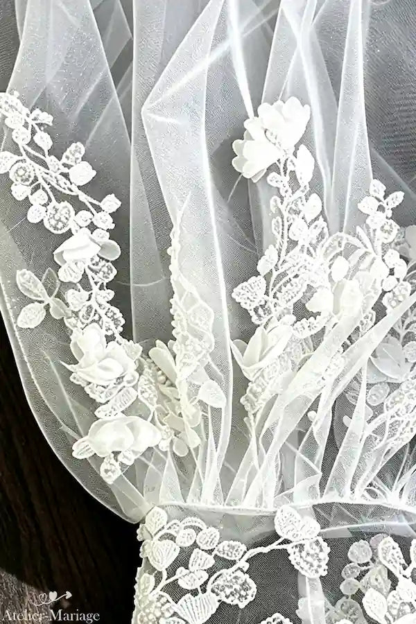 Détail des coutures et broderies fleuries faites main pour manches de mariée