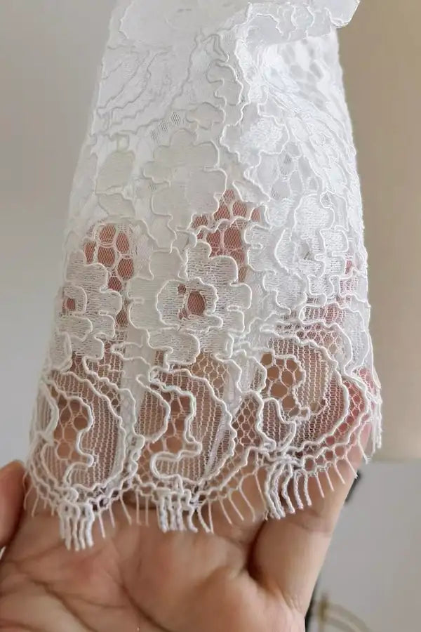 Détail de la bordure en dentelle florale de la manche bouffante — finition artisanale Atelier Mariage