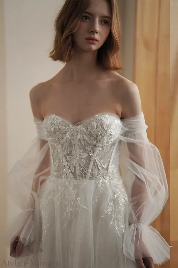 Détail de la petite manche couvrant l'épaule, ornée de perles et broderies florales.