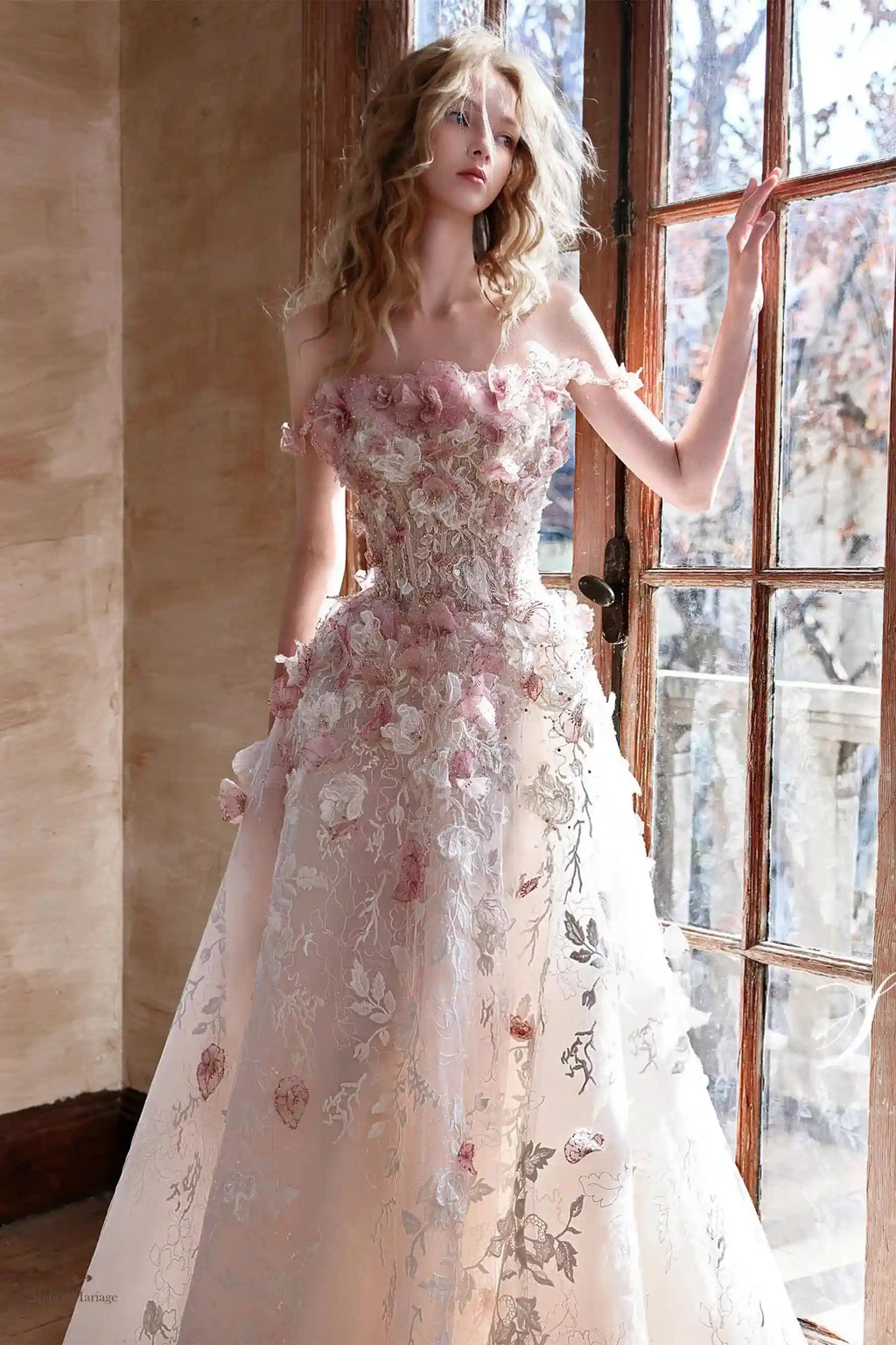 Détail haute couture des broderies et fleurs 3D sur le corsage de la robe de mariée rose poudré.