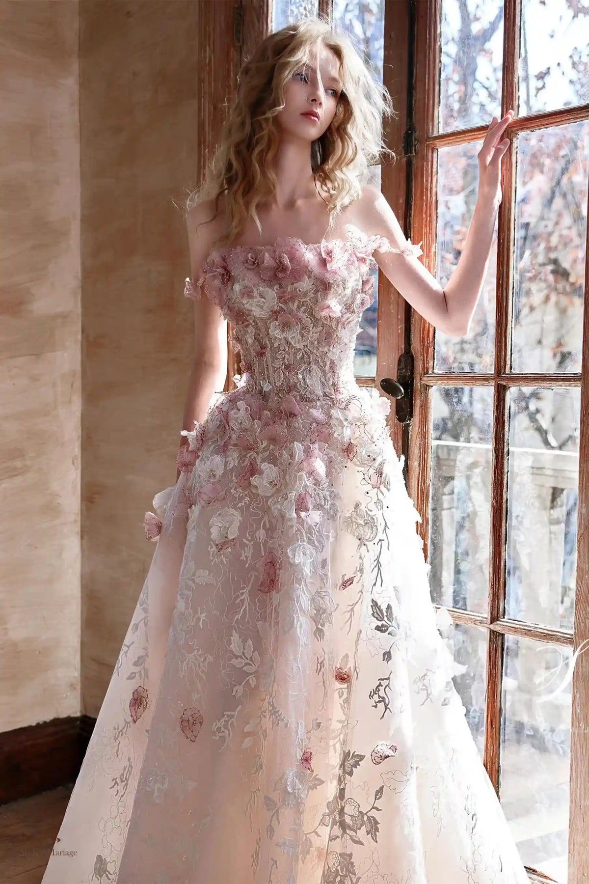 Détail haute couture des broderies et fleurs 3D sur le corsage de la robe de mariée rose poudré.