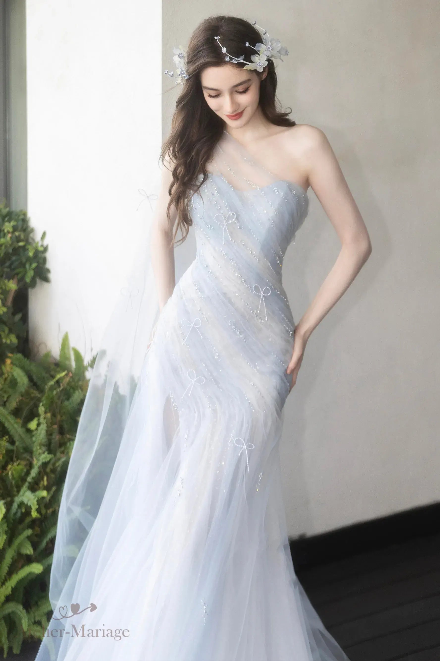 Détail haute couture du tulle plissé et des finitions scintillantes sur la robe bleu pastel.